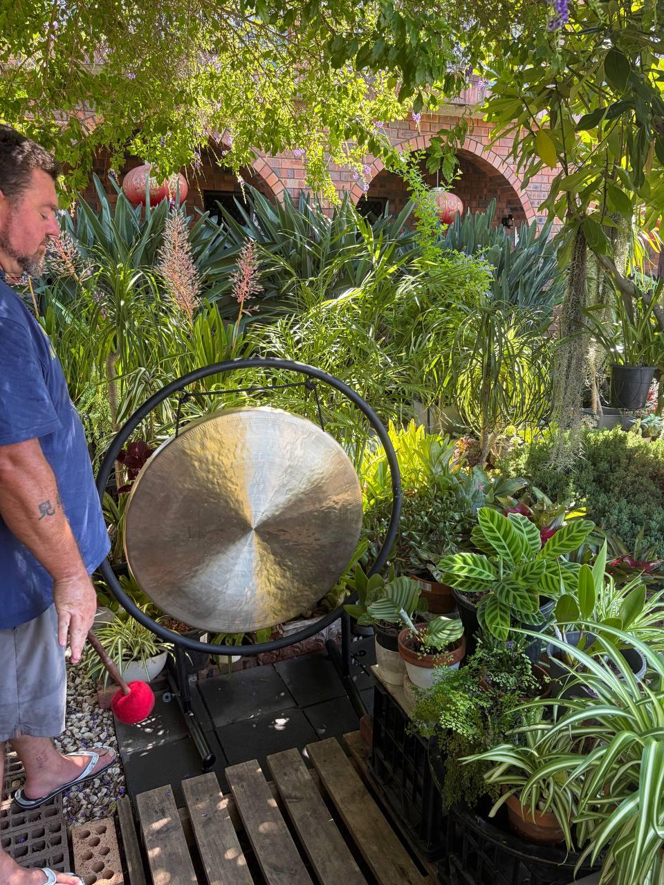 Luke standing with gong